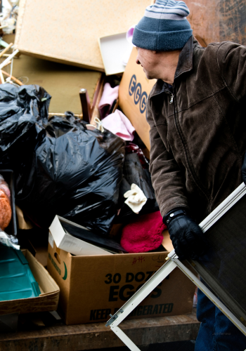 Man at a house removing junk