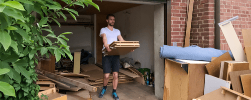 Man cleaning out a house with boxes in his hands