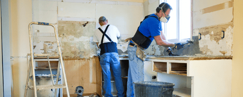 Men clearing out a kitchen of cabinets and appliances