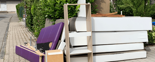 Mattress and bed frame sitting outside of home