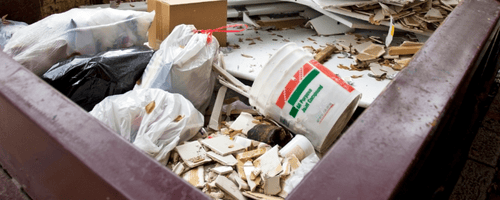 Metal bin full of junk at construction site.