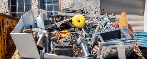 Pile of scrap metal sitting in metal bin, awaiting removal.